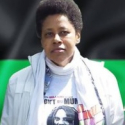 Militante panafricaine qui porte le tee-shirt pour exiger la libération de Mumia Abu-Jamal, sur fond du drapeau panafricain