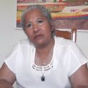Essayiste juriste Rosa Amelia Plumelle Uribe devant un tableau de port de pêche haïtien